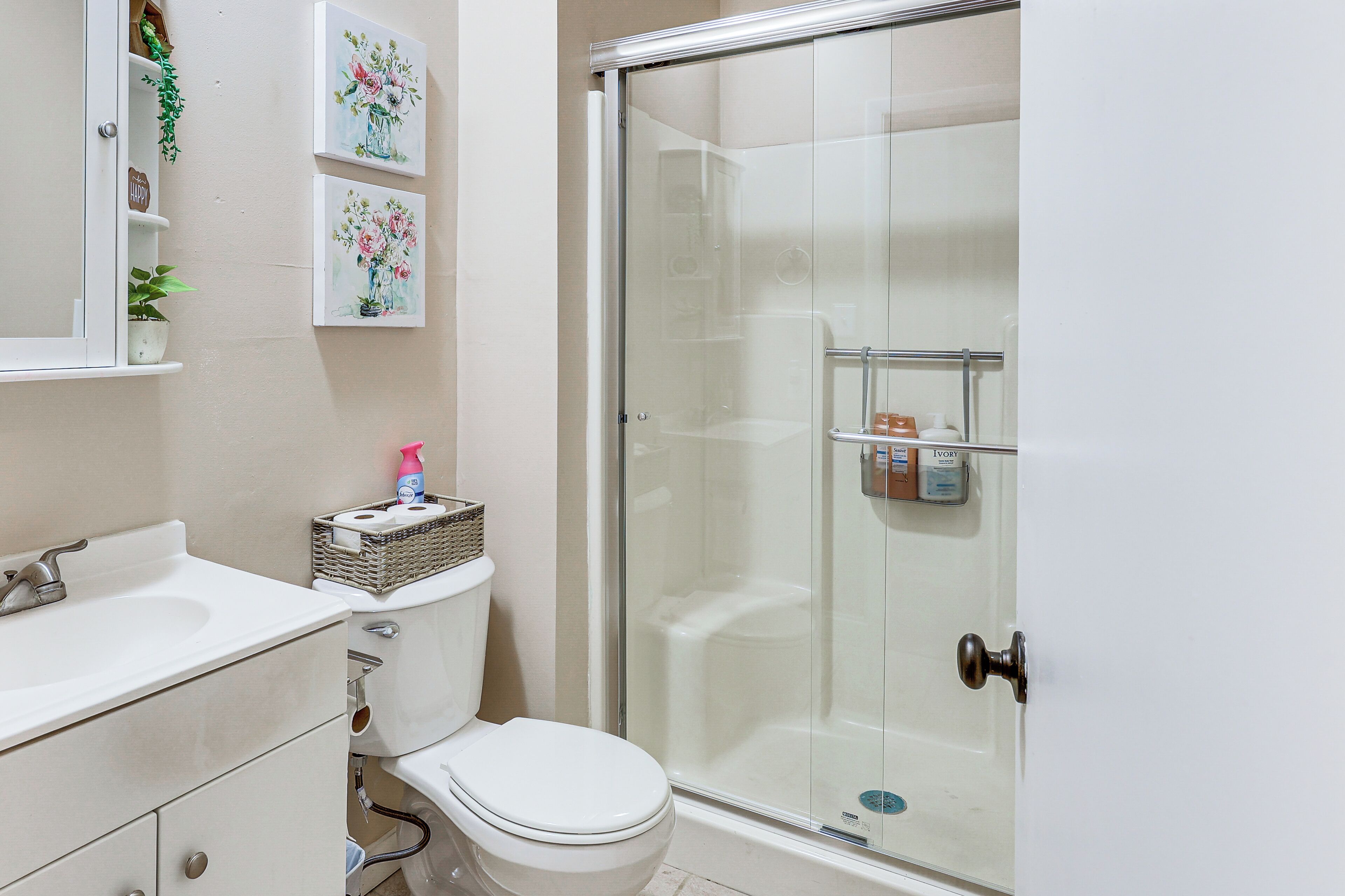A bathroom with a toilet, sink, and shower.