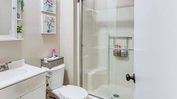 A bathroom with a toilet, sink, and shower.