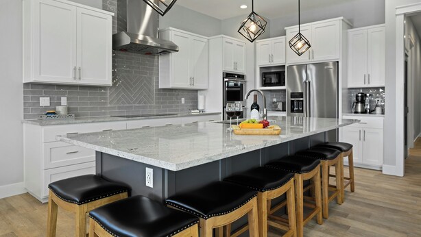 A modern kitchen with white cabinets, a large island with bar stools, stainless steel appliances, and pendant lighting. - Waterfront Home on Lake LBJ w/ Pool & Dock! (Kingsland)