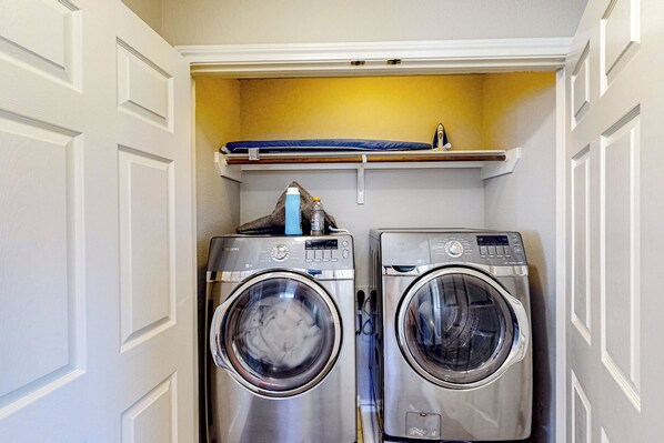 A compact laundry room with two stainless steel front-loading washing machines and a small shelf above them. - 3 Mi to Downtown Conroe: Updated Townhome w/ Yard (Conroe)