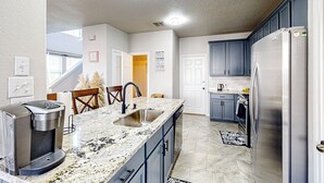 A modern kitchen with a built-in coffee maker, stainless steel appliances, and a granite countertop. - 3 Mi to Downtown Conroe: Updated Townhome w/ Yard (Conroe)