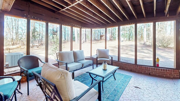 A covered outdoor seating area with a wooden ceiling, large windows, and a view of the surrounding forest. - 6 Mi to Dtwn: 'macon Memories' Dog-friendly Haven (Macon)