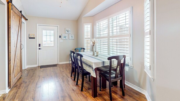 A dining area with a table set for four, a ceiling fan, and a door leading to another room. - Dog-friendly Yard! Retreat 11 Mi to Destin & Beach (Niceville)
