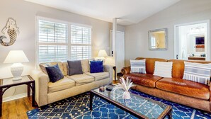 A living room with a beige sofa, a brown leather sofa, a glass coffee table, and a blue patterned rug. - Dog-friendly Yard! Retreat 11 Mi to Destin & Beach (Niceville)