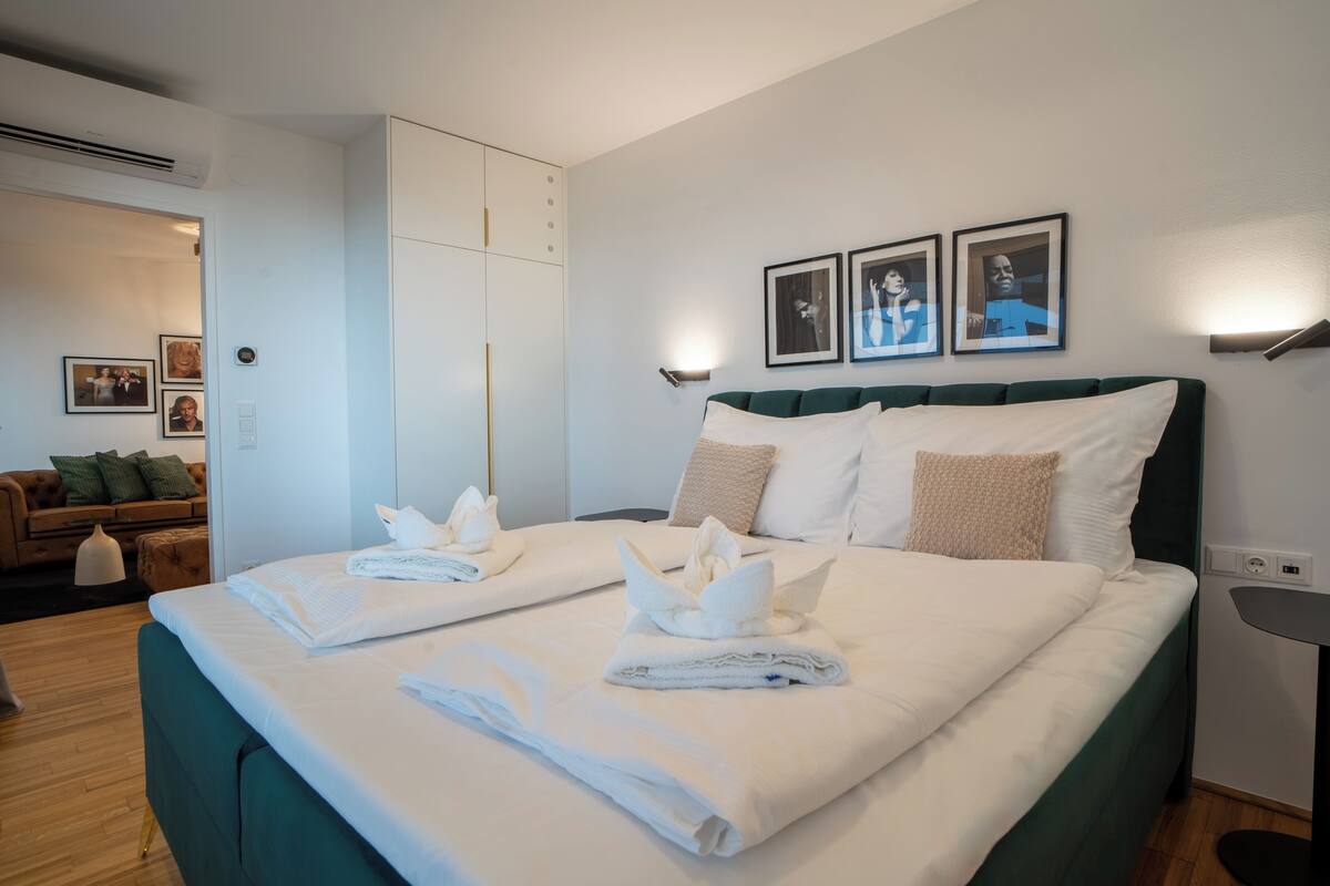 Una habitación de hotel con una cama grande, un armario, un sofá y cuadros en la pared.