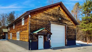 A log cabin with a garage, a small porch, and a clear sky. - 12 Mi to Lake George! Quiet Adirondack Escape (Fort Ann)
