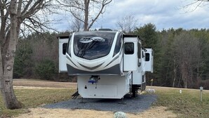A white RV with a "Solitude" logo, parked on a gravel path with trees in the background. - 12 Mi to Lake George! Quiet Adirondack Escape (Fort Ann)