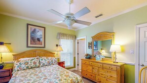A bedroom with a bed, dresser, chair, and ceiling fan. - Dog-friendly Riverfront 3BR w/ Fire Pit & Dock (Bell)