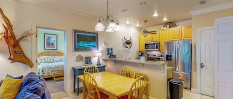 A compact living space with a dining area, kitchen, and a bedroom.