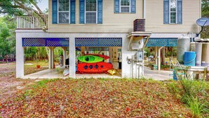 A two-story house with a covered porch, a satellite dish, and a large water tank. - Dog-friendly Riverfront 3BR w/ Fire Pit & Dock (Bell)