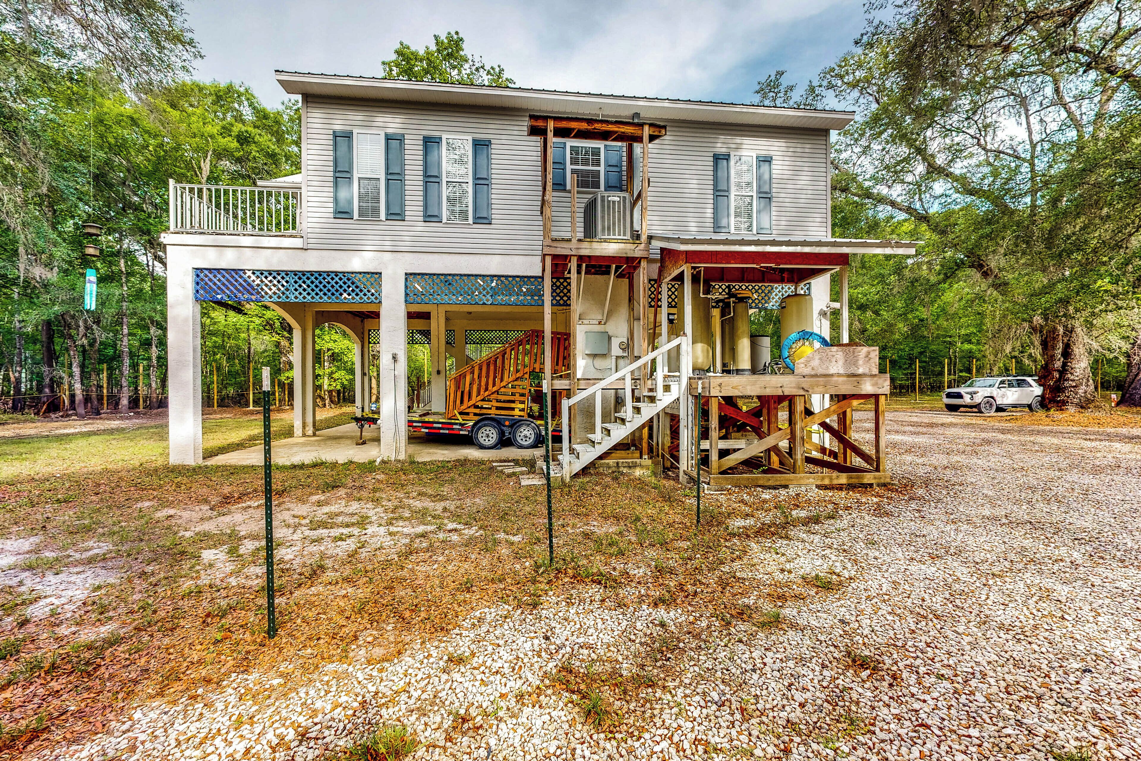 A two-story house with a covered porch, a staircase, and a truck parked outside.