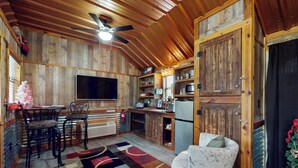 Un intérieur rustique en bois comprenant un coin repas, une cuisine et un espace détente.