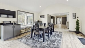 A spacious kitchen with a dining area, large windows, and a welcoming sign. - Outdoor Wonderland! Home 12 Mi to Lake George (Fort Ann)