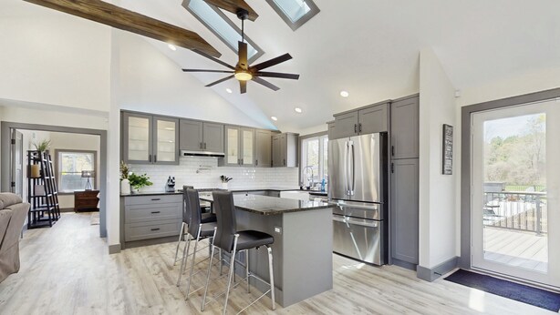A modern kitchen with a central island, grey cabinets, stainless steel appliances, and a ceiling fan. - Outdoor Wonderland! Home 12 Mi to Lake George (Fort Ann)