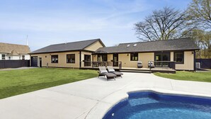 A modern house with a swimming pool, a patio with two lounge chairs, and a well-maintained lawn. - Outdoor Wonderland! Home 12 Mi to Lake George (Fort Ann)