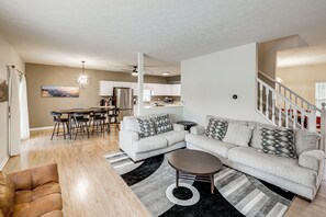 A modern living room with a sectional sofa, a coffee table, and a dining area with chairs and a table. - 2 Mi to Arts & Design District: Retreat w/ Yard (Carmel)