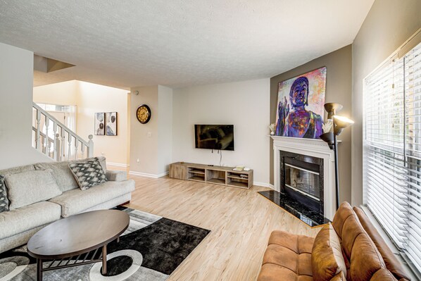 A living room with a sofa, a coffee table, a fireplace, and a television. - 2 Mi to Arts & Design District: Retreat w/ Yard (Carmel)
