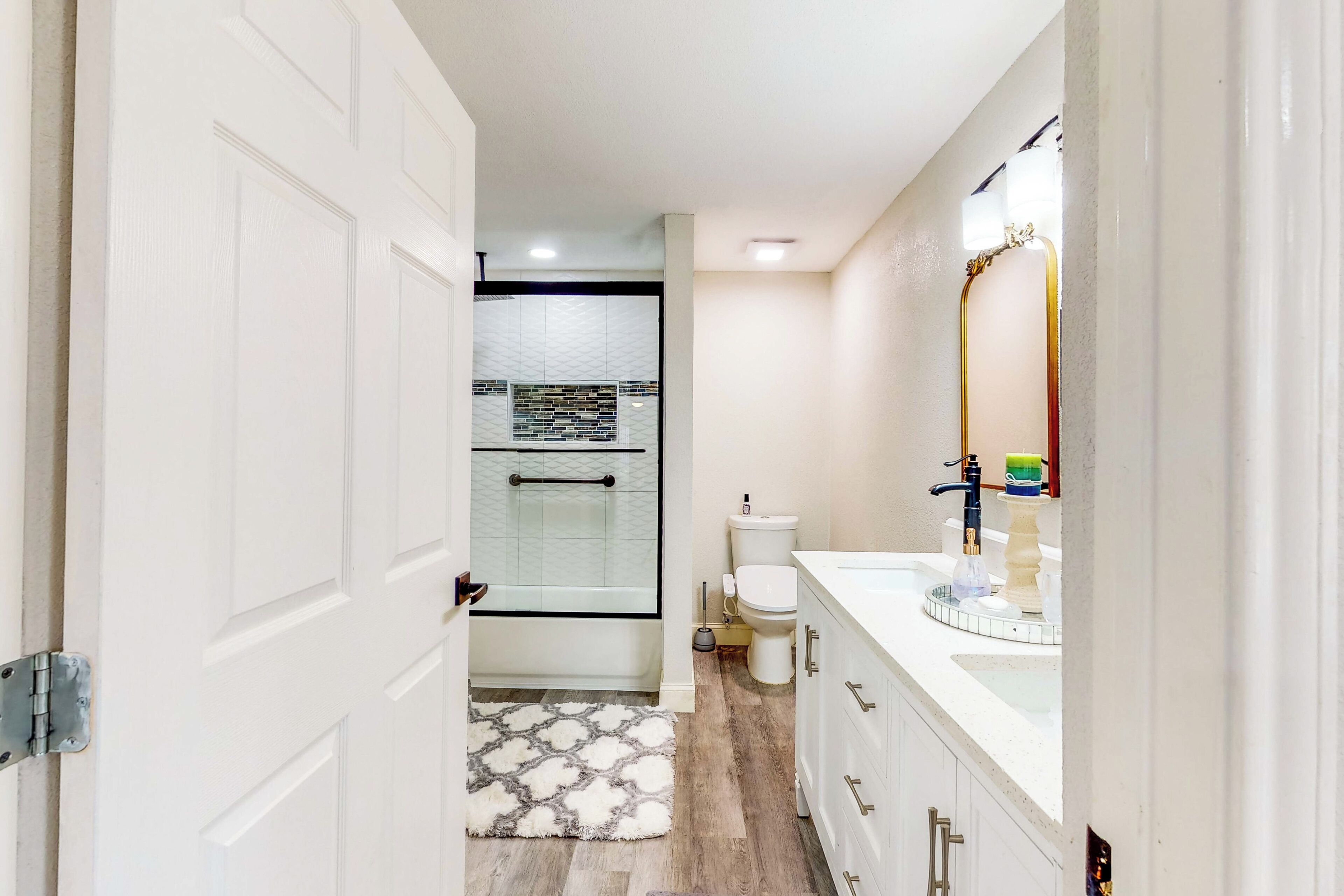 A bathroom with a shower, toilet, and vanity.