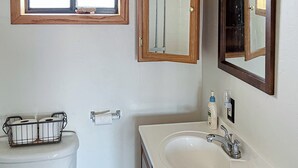 A bathroom with a toilet, a sink, a mirror, and a window above the toilet. - 1BR Casita w/ Mountain Views, Kitchenette, Wifi (Rimrock)