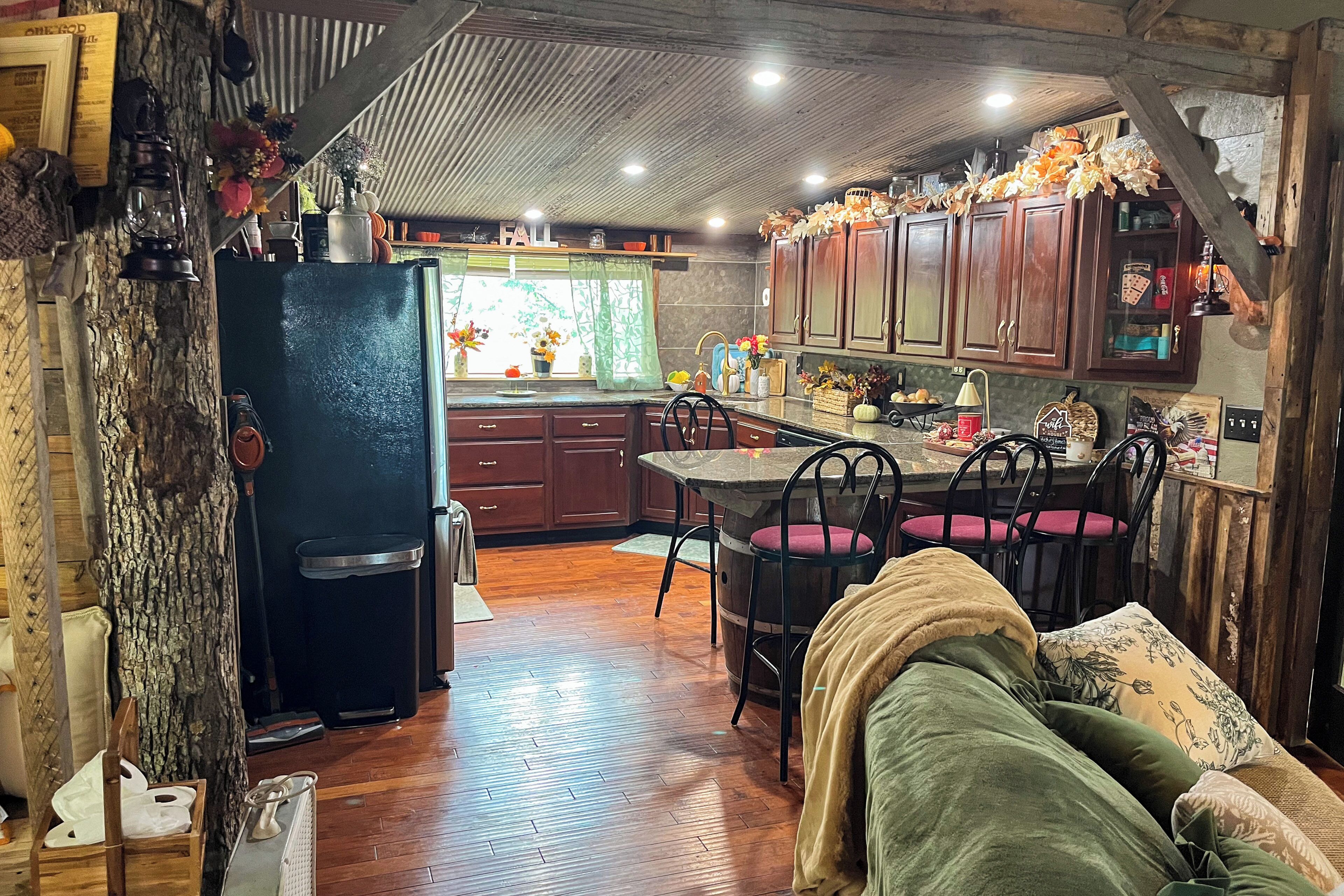 Une cuisine rustique avec des meubles en bois, un coin repas avec une table et des chaises, et un espace de vie chaleureux avec un canapé.