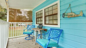 A porch with blue chairs, a wooden table, and a 'Welcome' sign. - Endless Entertainment! Unique & Cozy Theodore Home (Theodore)