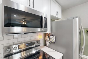 Una cocina moderna con electrodomésticos de acero inoxidable, incluyendo un microondas, horno y refrigerador.
