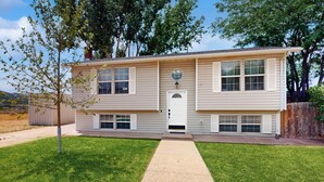 A two-story house with a front porch, a small front yard, and a wooden fence. - History, Hikes & Cozy Nights: Parowan Gem w/ Deck! (Parowan)