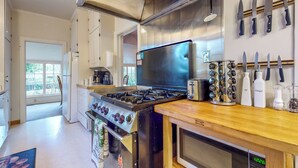 A modern kitchen with stainless steel appliances, a wooden countertop, and a knife rack. - Forbestown Retreat: Easy Access to Clear Lake (Lakeport)