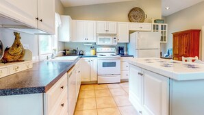 A kitchen with white cabinets, a stove, a microwave, and a refrigerator. - Homestead Cottage < 2 Mi to Salt Creek (Dallas)