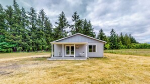 A single-story house with a porch, a small deck, and a front door. - Homestead Cottage < 2 Mi to Salt Creek (Dallas)