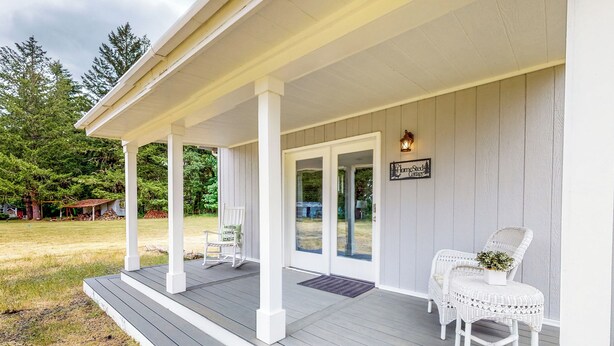 A porch with two white wicker chairs, a small table, and a potted plant. - Homestead Cottage < 2 Mi to Salt Creek (Dallas)
