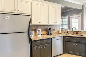 A kitchen with a refrigerator, coffee maker, and a sink. - 3 BR Cozy Family Home w/ Playground (Valdosta)