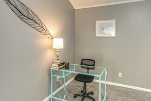 A workspace with a desk, chair, lamp, and books. - 3 BR Cozy Family Home w/ Playground (Valdosta)