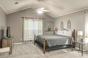 A bedroom with a bed, a desk, a chair, a ceiling fan, and a window with curtains. - 3 BR Cozy Family Home w/ Playground (Valdosta)