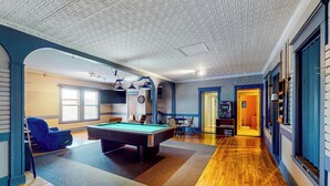 Un biliardo in una stanza con pavimento in legno e pareti blu.