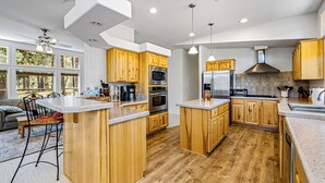 Une cuisine moderne avec des meubles en bois, des appareils électroménagers en acier inoxydable et un grand îlot central.