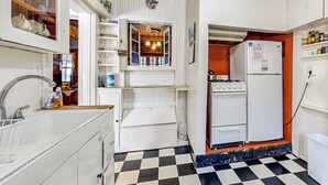 A compact kitchen with white cabinetry, a black and white checkered floor, a built-in oven, and a refrigerator. - 6BR Lakefront Estate w/ Private Piers & Patios (Ripon)