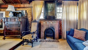A traditional living room with a fireplace, wooden furniture, and a blue sofa. - 6BR Lakefront Estate w/ Private Piers & Patios (Ripon)