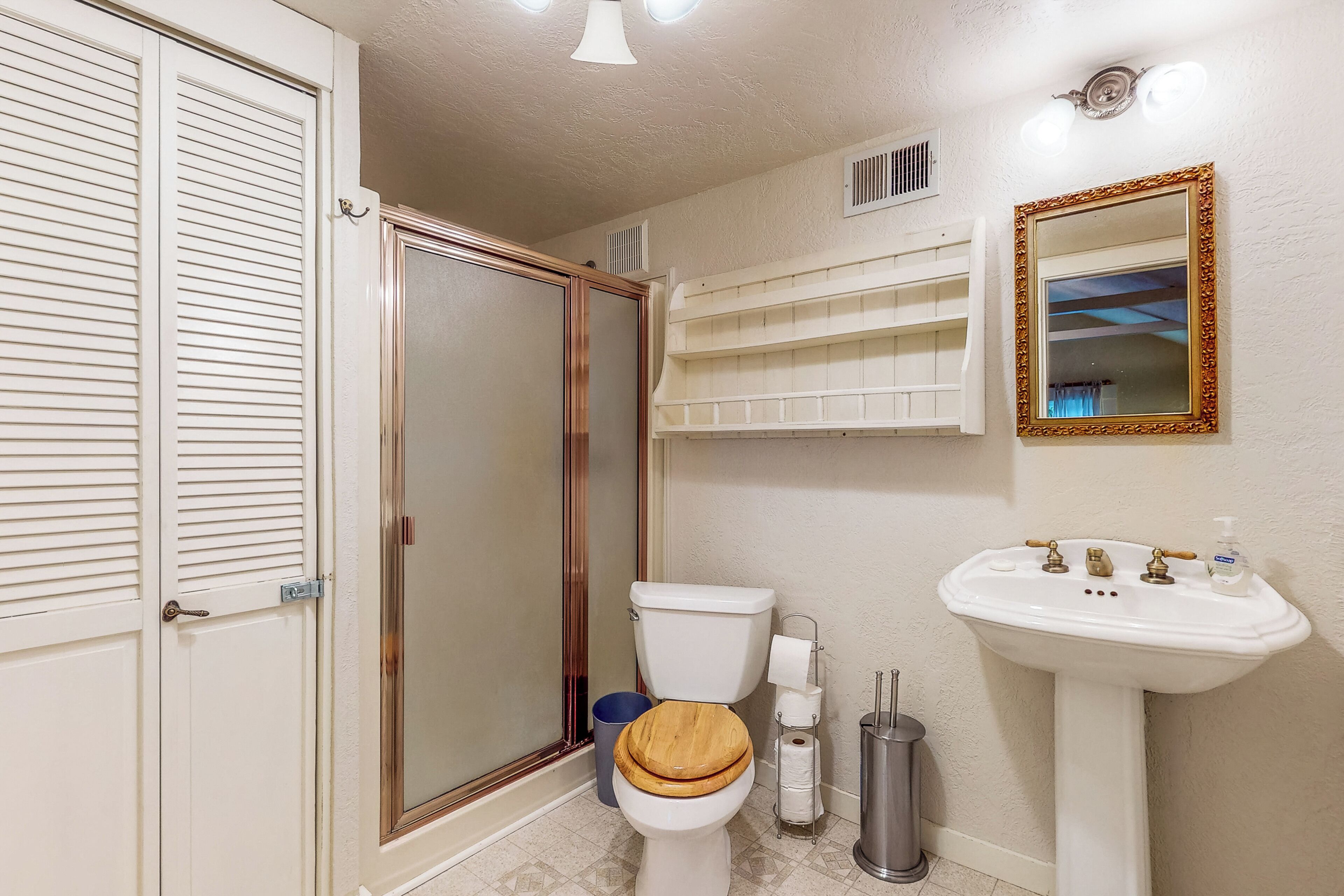 A bathroom with a toilet, sink, and shower.