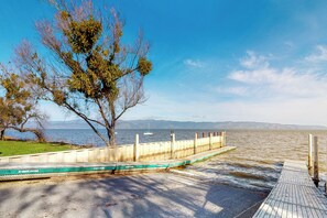 A waterfront dock with a concrete barrier and a wooden walkway. - Forbestown Carriage House in the Heart of Dtwn (Lakeport)