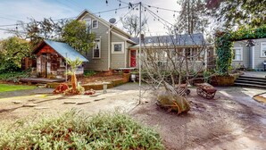 Il s’agit d’une propriété résidentielle comprenant une maison, un petit abri de jardin et un jardin avec un arbre et diverses plantes.