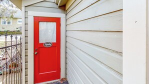 Une porte rouge avec une fenêtre, une boîte aux lettres et une autre boîte aux lettres portant l’inscription « Laverie ».