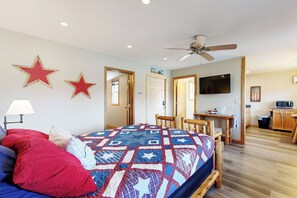 A bedroom with a bed, a desk, a television, and a ceiling fan. - Blue Line Resort - All 3 Cabins! (Murphysboro)
