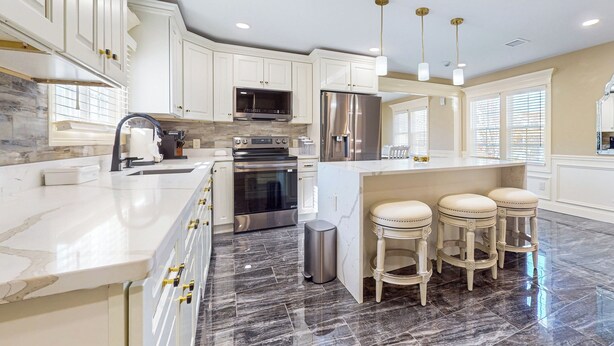 A modern kitchen with white cabinetry, stainless steel appliances, and a marble countertop. - Steps to Holyoke Medical Center! Remote-work Hub (Holyoke)