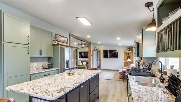 A kitchen with granite countertops, stainless steel appliances, and light green cabinetry. - Newly Updated Countryside Home in South Gorin! (South Gorin)