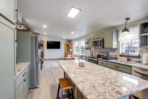 A modern kitchen with a large island, built-in appliances, and ample counter space. - Newly Updated Countryside Home in South Gorin! (South Gorin)