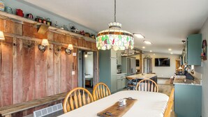 A dining area with a wooden table, chairs, and a chandelier. - Newly Updated Countryside Home in South Gorin! (South Gorin)