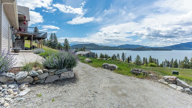 A house with a balcony overlooking a lake, surrounded by greenery and mountains. - Breathtaking Mountain & Lake Views! (Dayton)