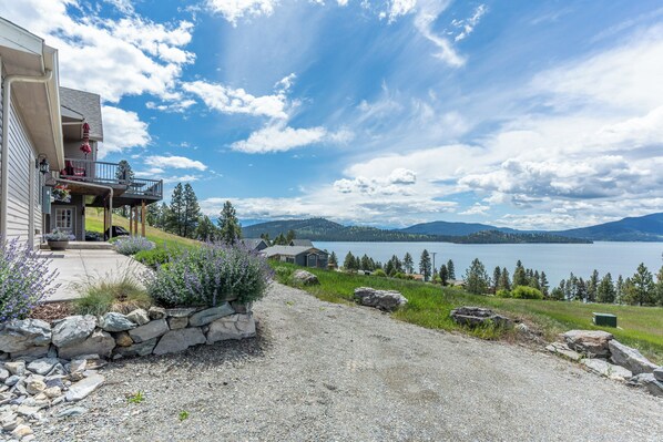 A house with a balcony overlooking a lake, surrounded by greenery and mountains. - Breathtaking Mountain & Lake Views! (Dayton)