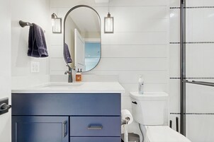 Un baño moderno con un lavamanos blanco, un mueble de baño azul y un inodoro.